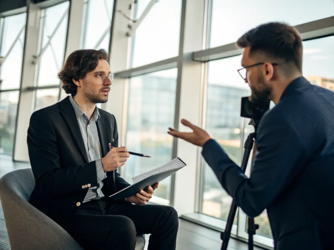 A professional journalist interviewing a company's CEO in a modern office setting, symbolizing media engagement and visibility.